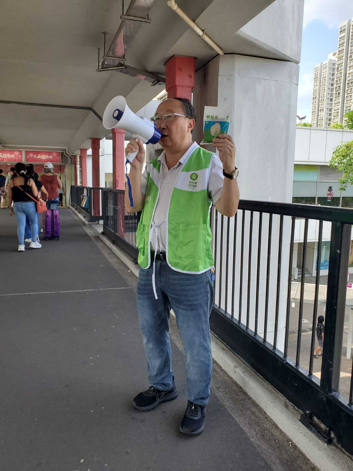 Oxfam supporter speaking through a megaphone (Hong Kong)